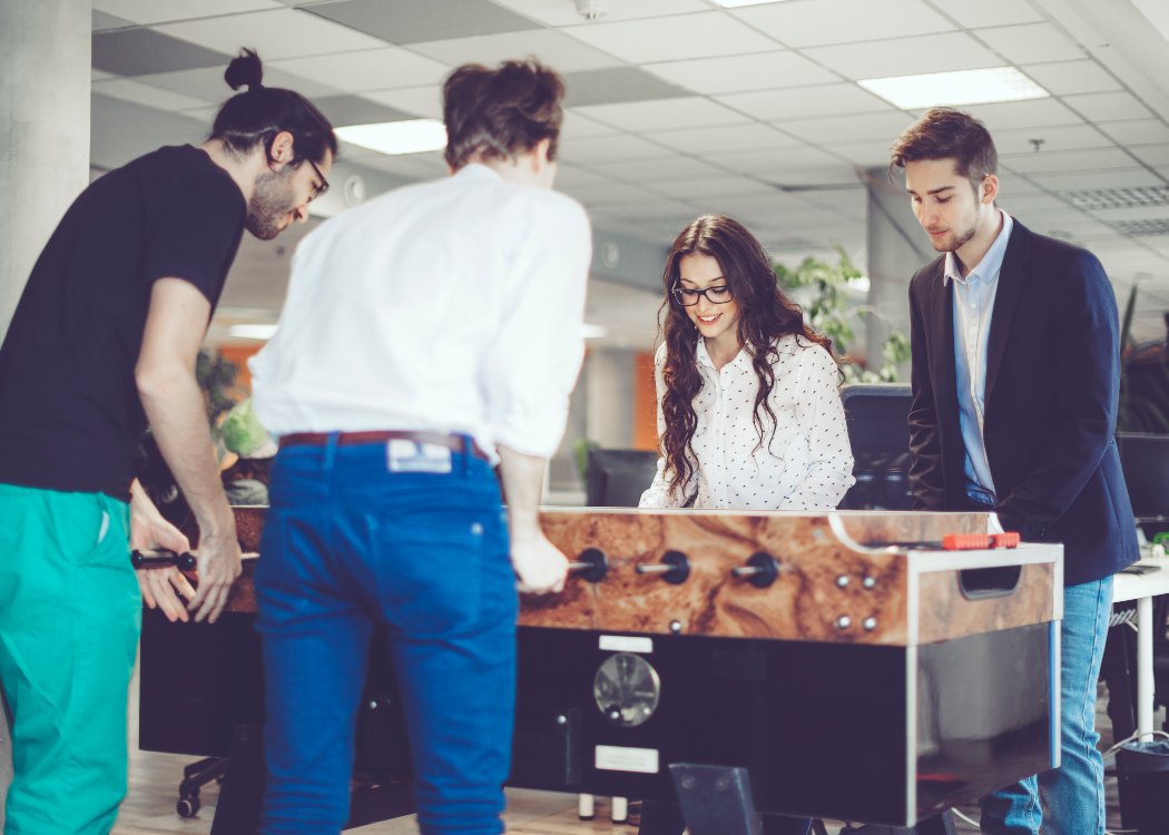 Coworkers are playing foosball at work